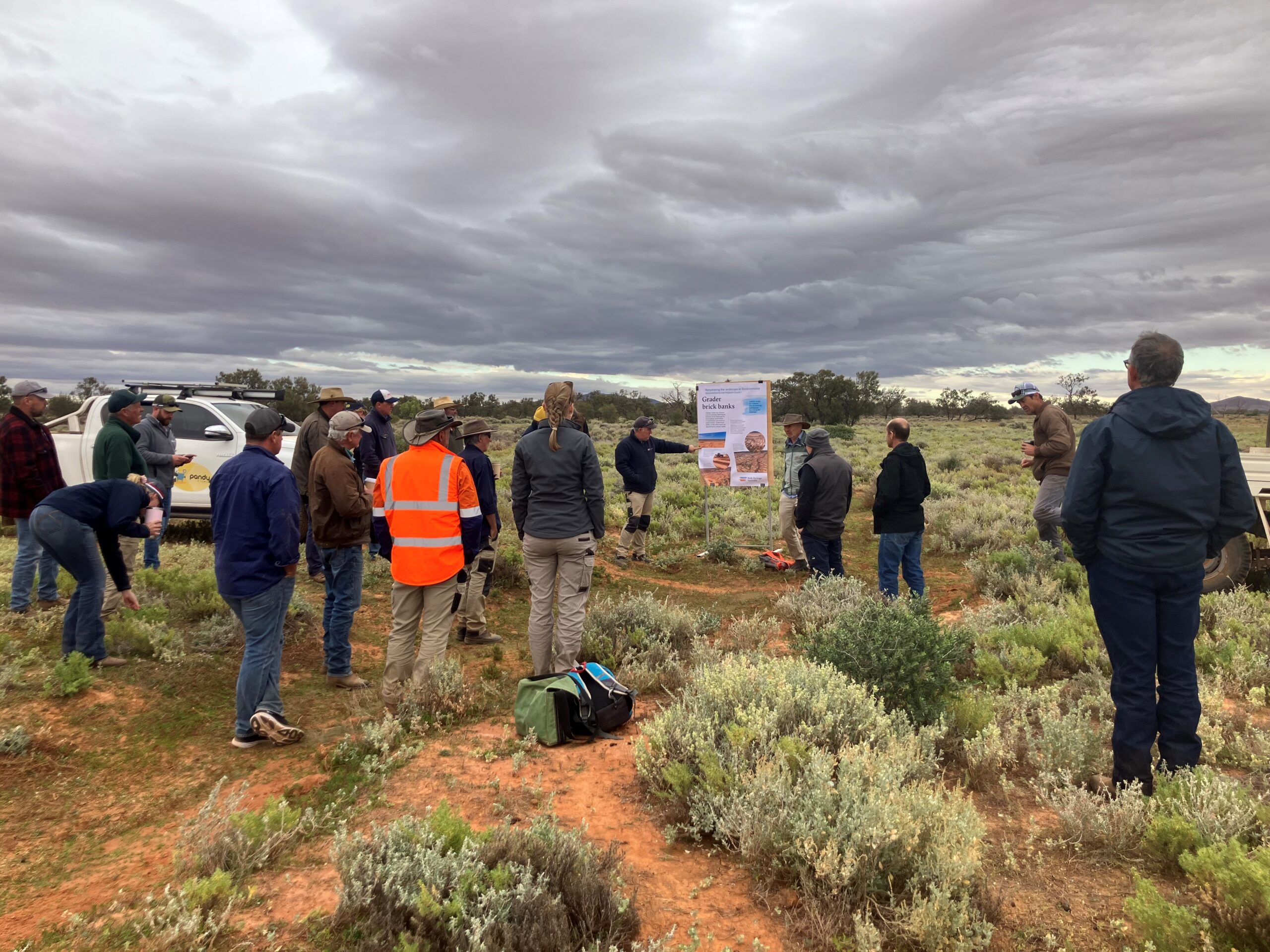 A large group of people looking at a sign.