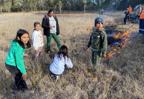 First Nations family group nearby as cultural burning is happening.