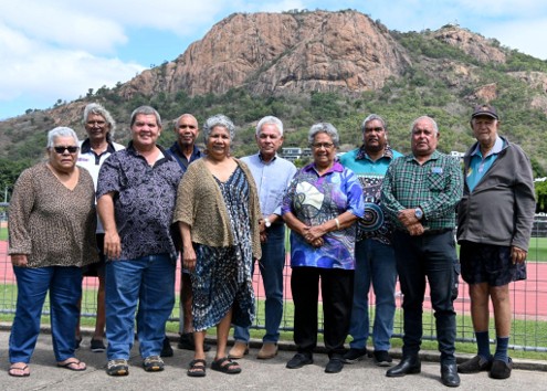 Group of people posing for the camera with rock outlier in the background.