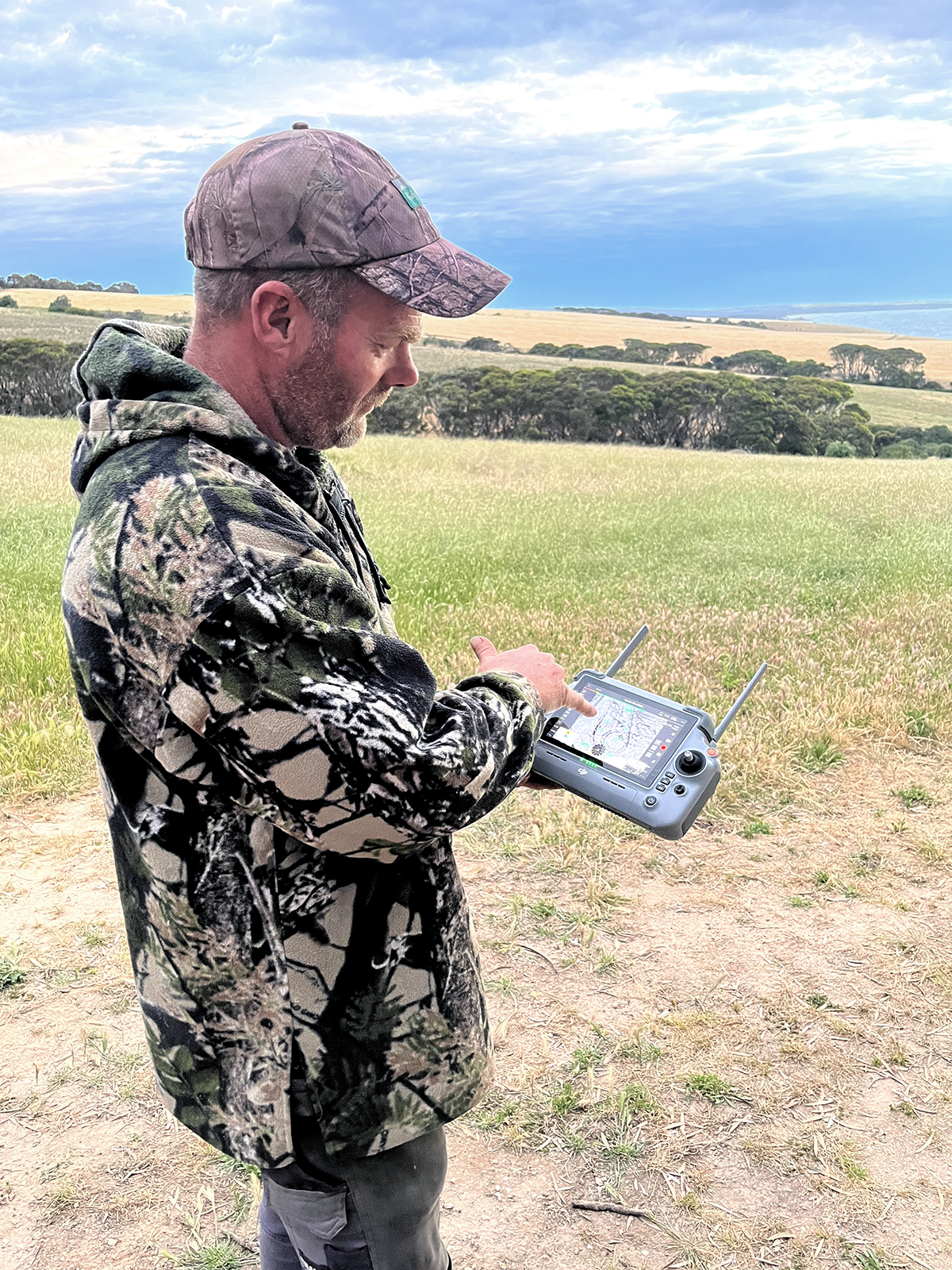 A person is holding a controller, used for flying a drone.